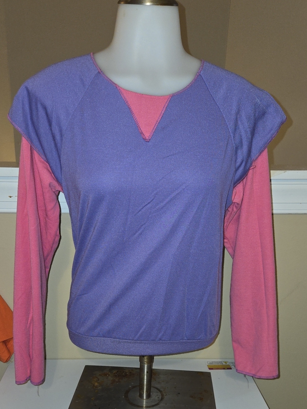 retro purple short-sleeve top layered over pink long sleeves, featuring a distin